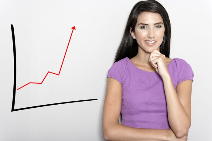 Professional working woman in corporate purple dress, with a concept graph displaying an increase..jpeg